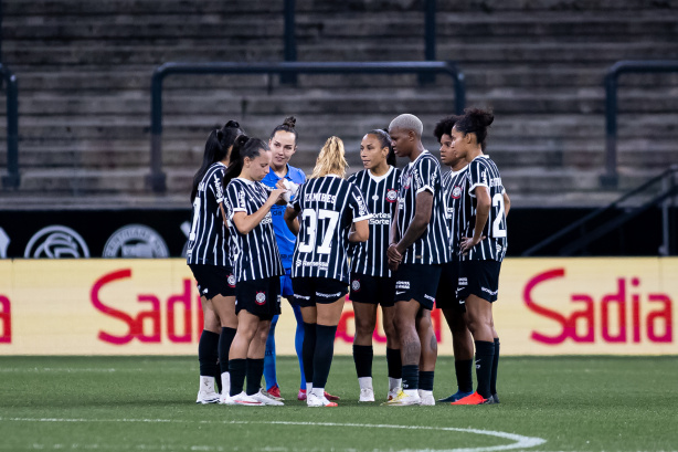 Elenco feminino do Corinthians comemorando gol com uniforme alvinegro.